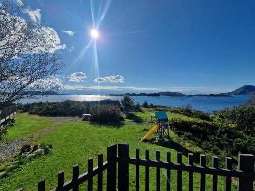 a fence in a field with a view of the water at Færøya 49 in Nekkøyane