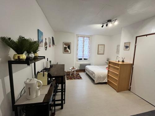 a bedroom with a bed and a table and a desk at Le Cocon 54 Studio à Rives Parking facile in Rives