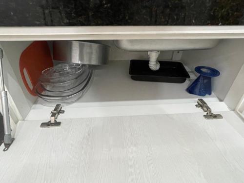 a kitchen sink with two faucets under a counter at Casa Centro de Caraguatatuba in Caraguatatuba
