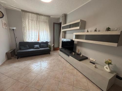 a living room with a couch and a television at Casa Debby in Serravalle Scrivia