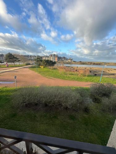 a view of a road next to a body of water at Maison port guillaume in Dives-sur-Mer