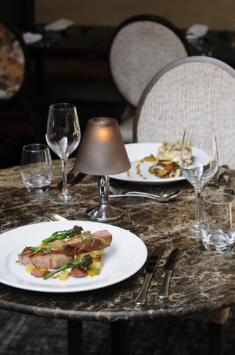 a table with two plates of food and wine glasses at Park Farm Hotel in Norwich