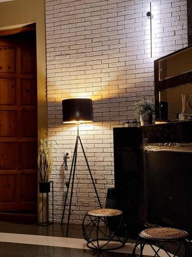 a lamp in a room with two chairs and a brick wall at Green Villa Tsaghveri in Tsaghveri