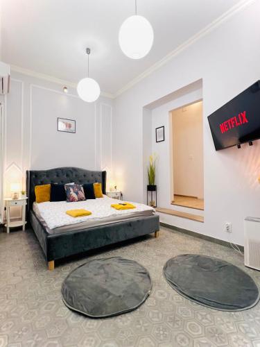 a bedroom with a bed and a flat screen tv at Sweet cozy studio ultracentral in Cluj-Napoca