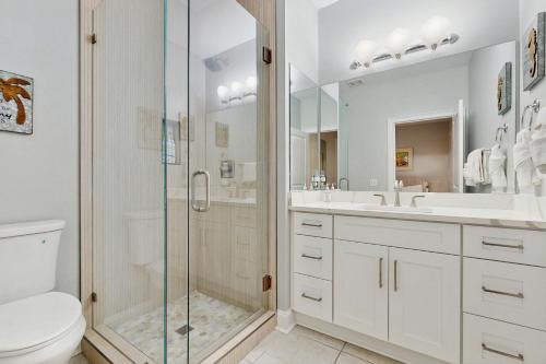 a white bathroom with a shower and a toilet at Topsail Village #511 - Beach Moon in Santa Rosa Beach