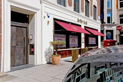 a store with a red awning on a street at 37GS Residences in London