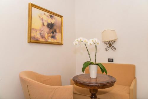 a table with a vase of flowers on a table at Hotel Miramare in Lignano Sabbiadoro