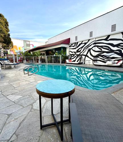 a swimming pool with a table next to a building at Park Plaza Lodge in Los Angeles