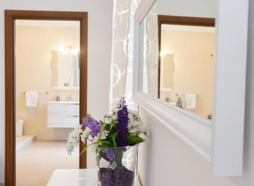 a vase of flowers sitting on a table in front of a mirror at La Locanda del Baffo in Capua
