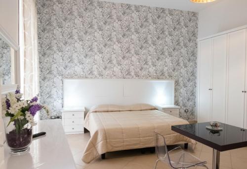 a bedroom with a bed and a floral wallpaper at La Locanda del Baffo in Capua