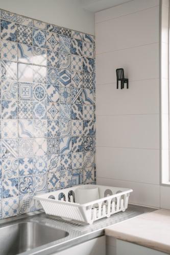 a kitchen with a sink and blue and white tiles at A Praia My Own Paradise T2 1º Andar in Figueira da Foz