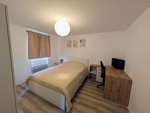 a bedroom with a bed and a desk with a computer at Escale Im Elsass in Mutzig