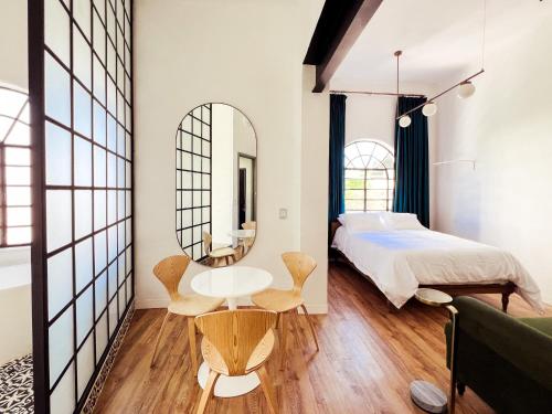 a bedroom with a bed and a table and a mirror at La Casona in Guadalajara