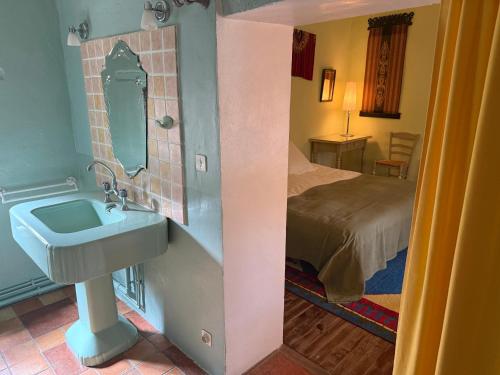 a bathroom with a sink and a bed in a room at Belle de Nuit in Oppède