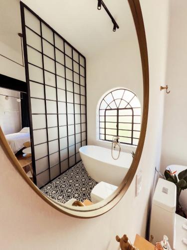 a bathroom with a round mirror and a bath tub at La Casona in Guadalajara