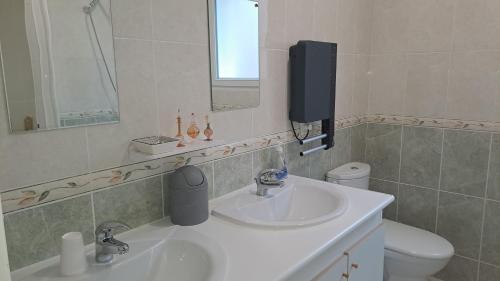 a bathroom with a sink and a mirror and a toilet at gîte de bon air in Sens-de-Bretagne