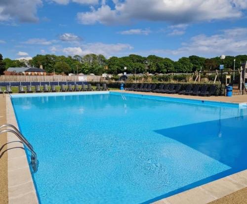 a large swimming pool with blue water at 3 Bed Luxury Mobile Home Hoburne Park Christchurch in Christchurch