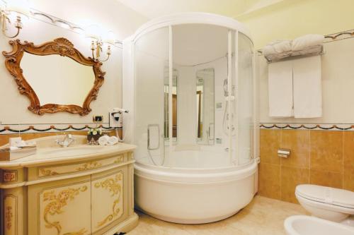 y baño con bañera, lavabo y aseo. en Grand Hotel President en Olbia