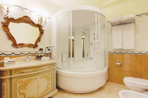 une salle de bain avec une baignoire, un lavabo et des toilettes dans l'établissement Grand Hotel President, à Olbia
