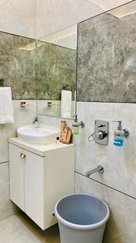 a bathroom with a sink and a toilet and a mirror at Hotel Madhur Pithampur in Akolia