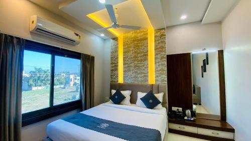 a bedroom with a bed and a large window at Hotel Madhur Pithampur in Akolia