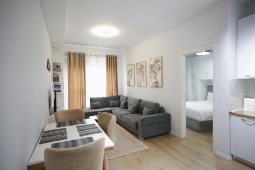 a living room with a couch and a bed at Shehu Apartments in Tirana