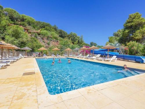 a large swimming pool with people in the water at ZEcamping 3 étoiles avec terrain multisports mini golf 2km plage dog friendly in Cargèse