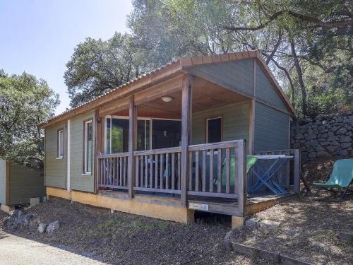 a tiny house with a porch and a deck at ZEcamping 3 étoiles avec terrain multisports mini golf 2km plage dog friendly in Cargèse