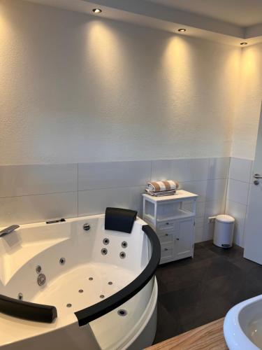 a white bathroom with a tub and a sink at Villa Belmonte in Weilheim an der Teck