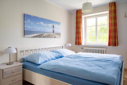 a bedroom with a bed with a lighthouse on the wall at Haus am Deich in Utersum