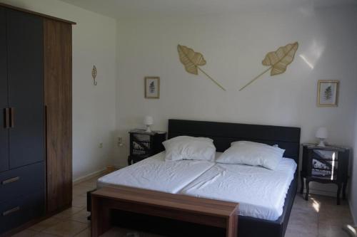 a bedroom with a bed with white sheets and pillows at Ferienhaus Alex in Großefehn 
