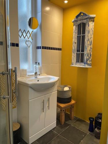 a bathroom with a white sink and a window at Hidden Gem in Stirling
