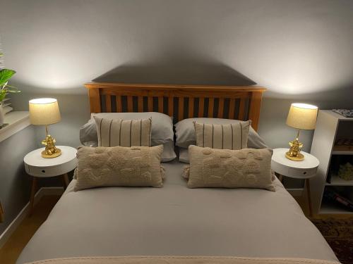a bedroom with a large white bed with two lamps at Hidden Gem in Stirling