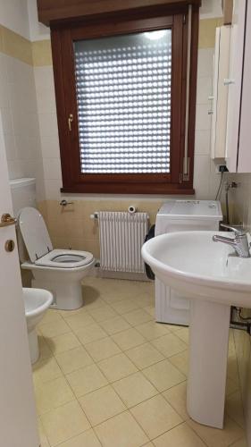 a bathroom with a toilet and a sink at Chiara Apartment in Cervignano with 2 Double Beds in Cervignano del Friuli