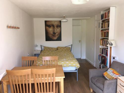a living room with a table and a bed at The River Flat in Oxford