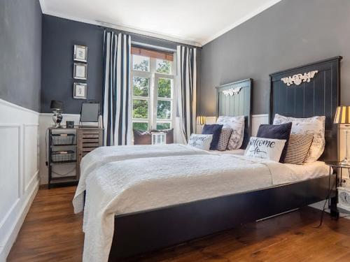 a bedroom with a large bed with blue walls at Ferienwohnung LA MAISON mit Sauna am See in Neuenkirchen
