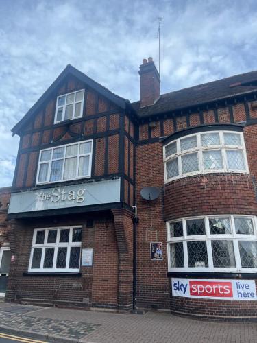 a brick building with a sign on the side of it at The Stag and Hen Pub in Coventry