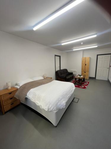 a white bedroom with a bed and a couch at The Stag and Hen Pub in Coventry