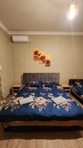 a bedroom with a bed with a blue comforter at my home in Kutaisi