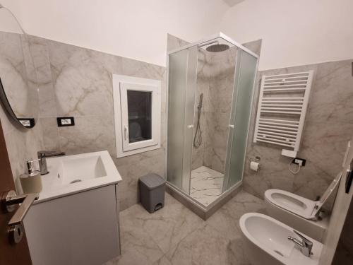 a bathroom with a shower and a sink and a toilet at Uddin House in Genoa
