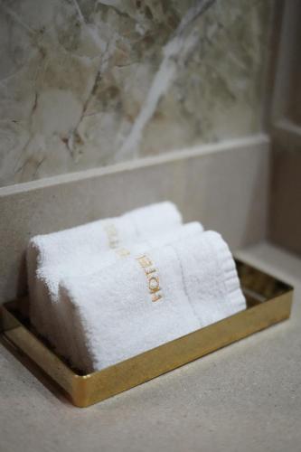 a pile of towels sitting on a tray in a bathroom at HOTEL BOCA Center in Tirana