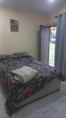 a bedroom with a bed with a colorful blanket at First derby Lodge in Benoni