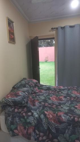 a bedroom with a bed with a colorful blanket and a window at First derby Lodge in Benoni