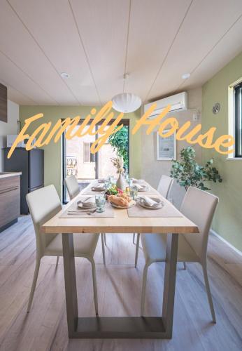 a dining room table with white chairs and a sign that reads earthquake house at HANA HOUSE Tokyo - Family House near Haneda Airport in Tokyo