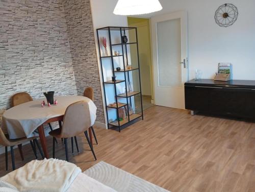 Appartement T3 في Pont-sur-Seine: غرفة معيشة بها طاولة وكراسي ورف
