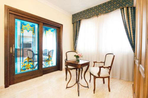 a room with a table and two chairs and a window at Grand Hotel President in Olbia
