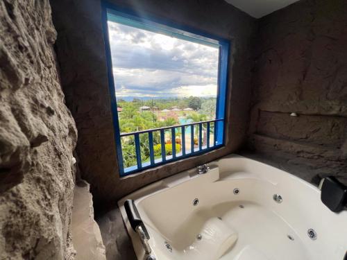 a bath tub in a room with a window at Mahawi Resort in Calarcá