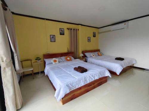 a bedroom with two beds with towels on them at Langkao Homestay Kohlibong หลังเขาโฮมสเตย์ เกาะลิบง in Ko Kwang