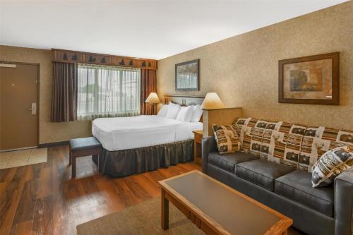 a hotel room with a bed and a couch at Best Western Plus Kelly Inn and Suites in Fargo