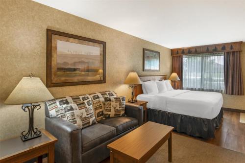 a hotel room with a bed and a couch at Best Western Plus Kelly Inn and Suites in Fargo